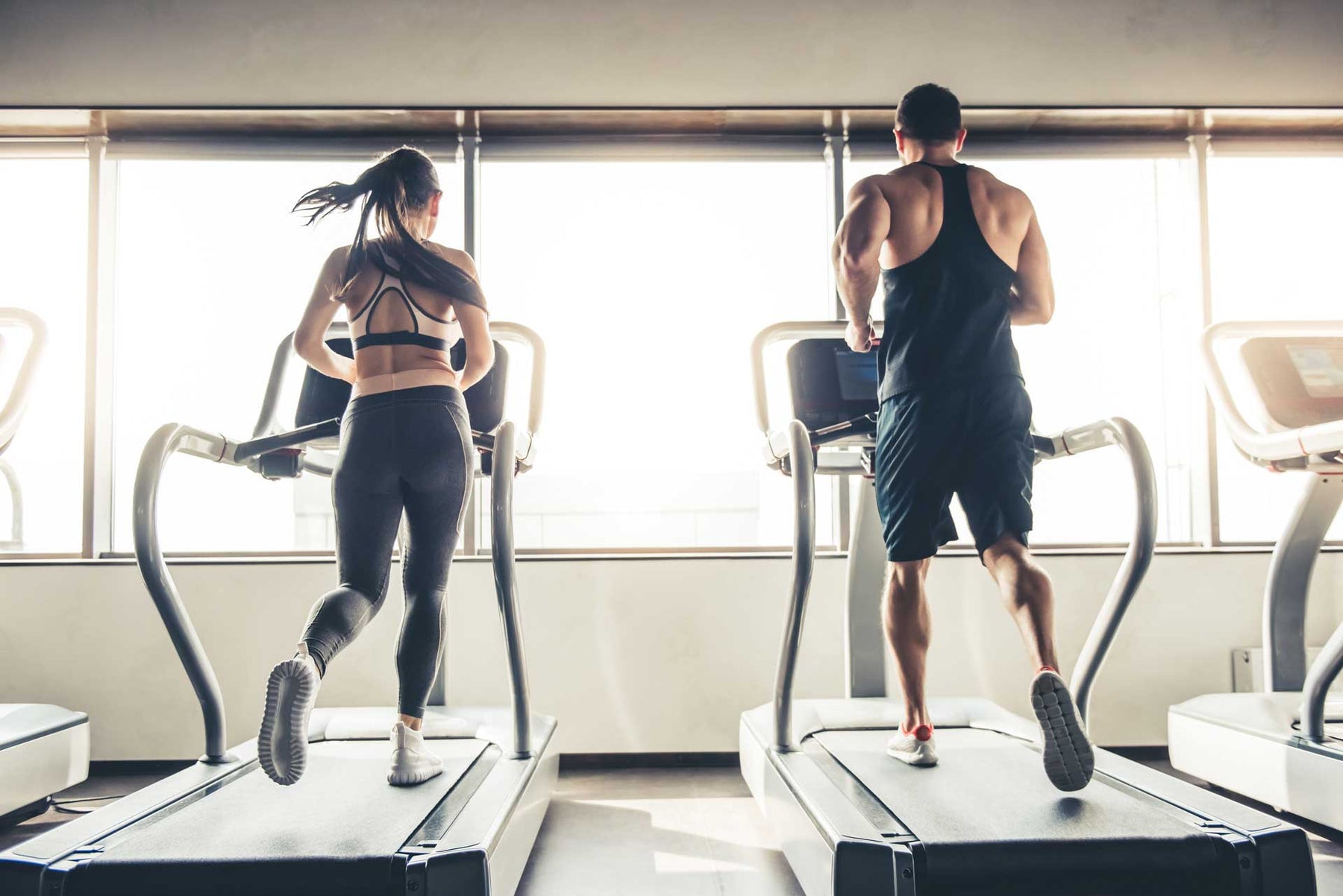 sports people running on a treadmill in gym