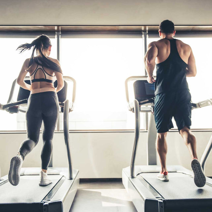sports people running on a treadmill in gym